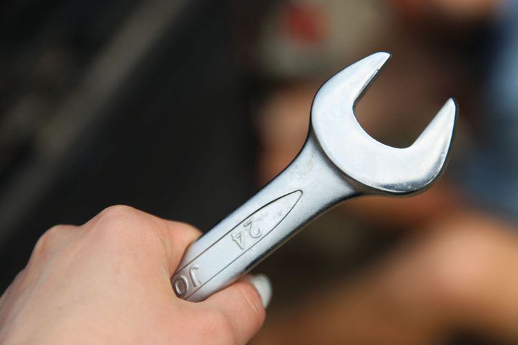 Hand holding an open-ended spanner
