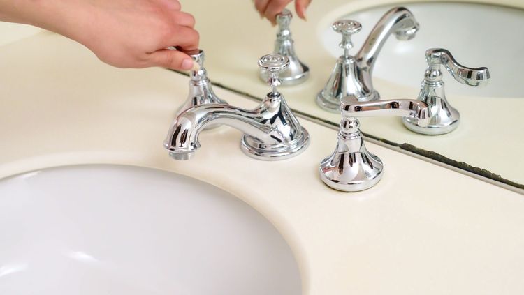 Hand fitting the handle cap on a basin tap