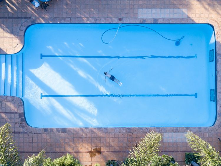 Residential swimming pool seen from above, with a pool cleaner in the water