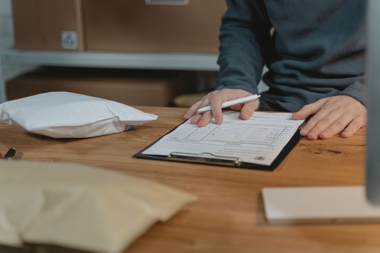 Hands filling in a quote on a clipboard